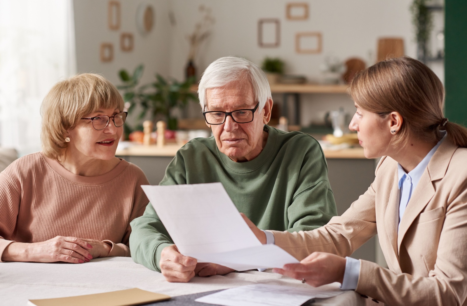 Two seniors discuss important documents with a professional-looking lady.
