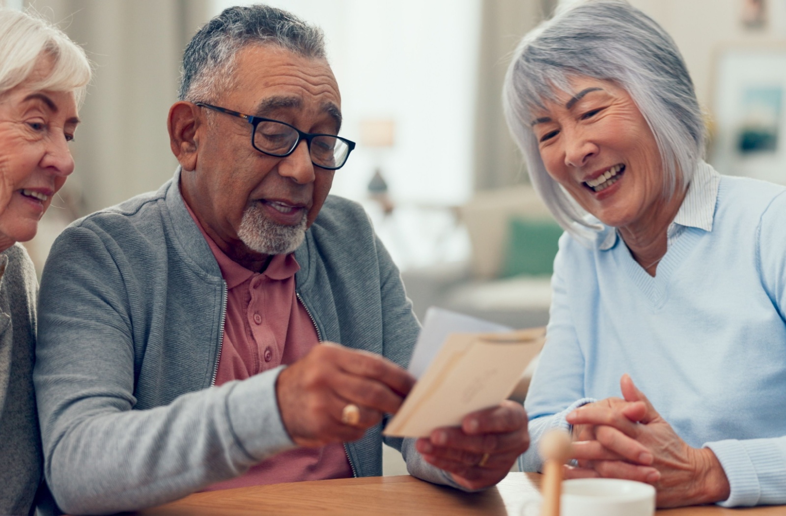 Three older adults in senior living use flash cards during a memory-strengthening exercise