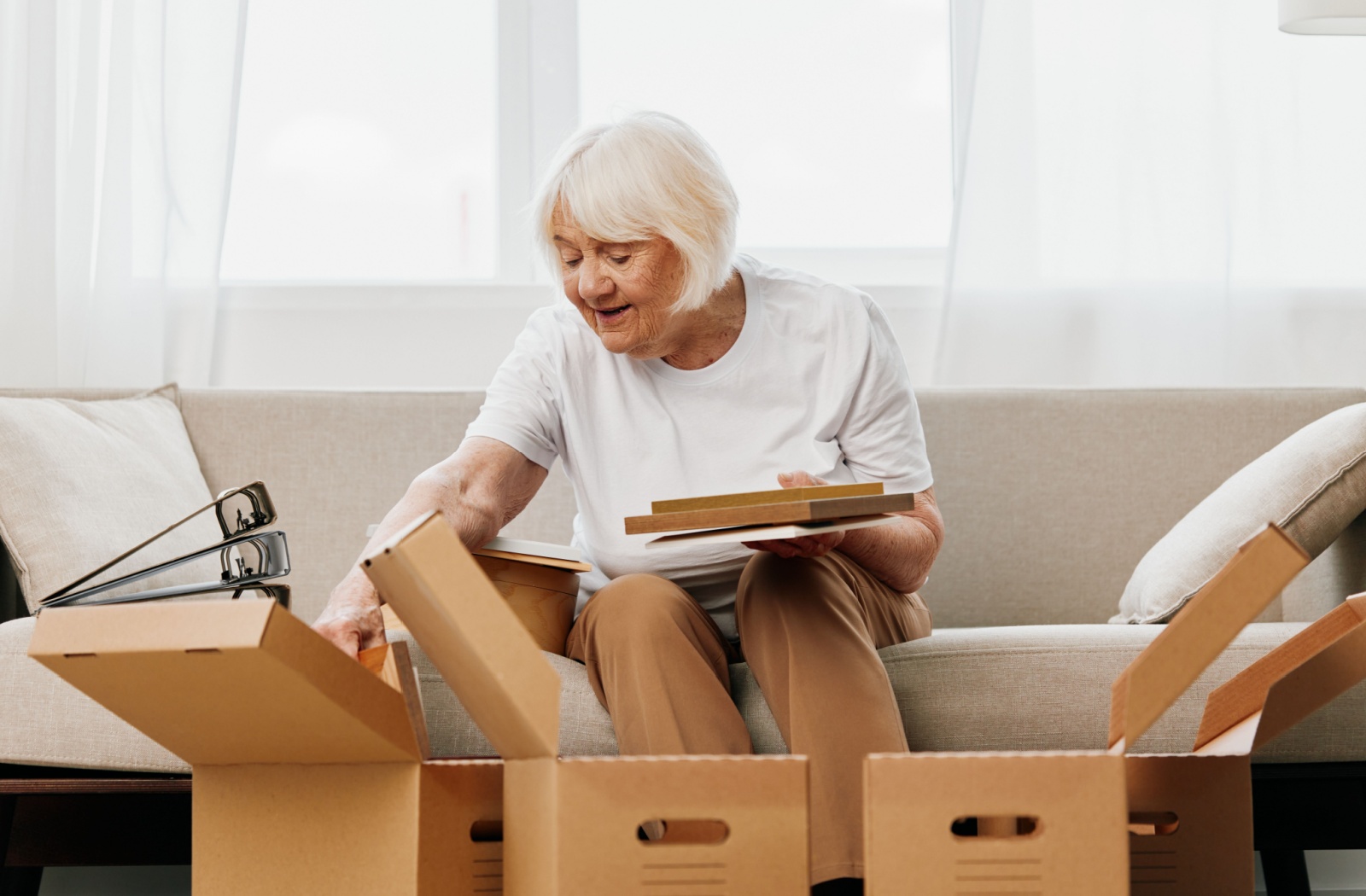 A senior reminisces fondly over pictures and mementos as they unpack in their new senior living community home.