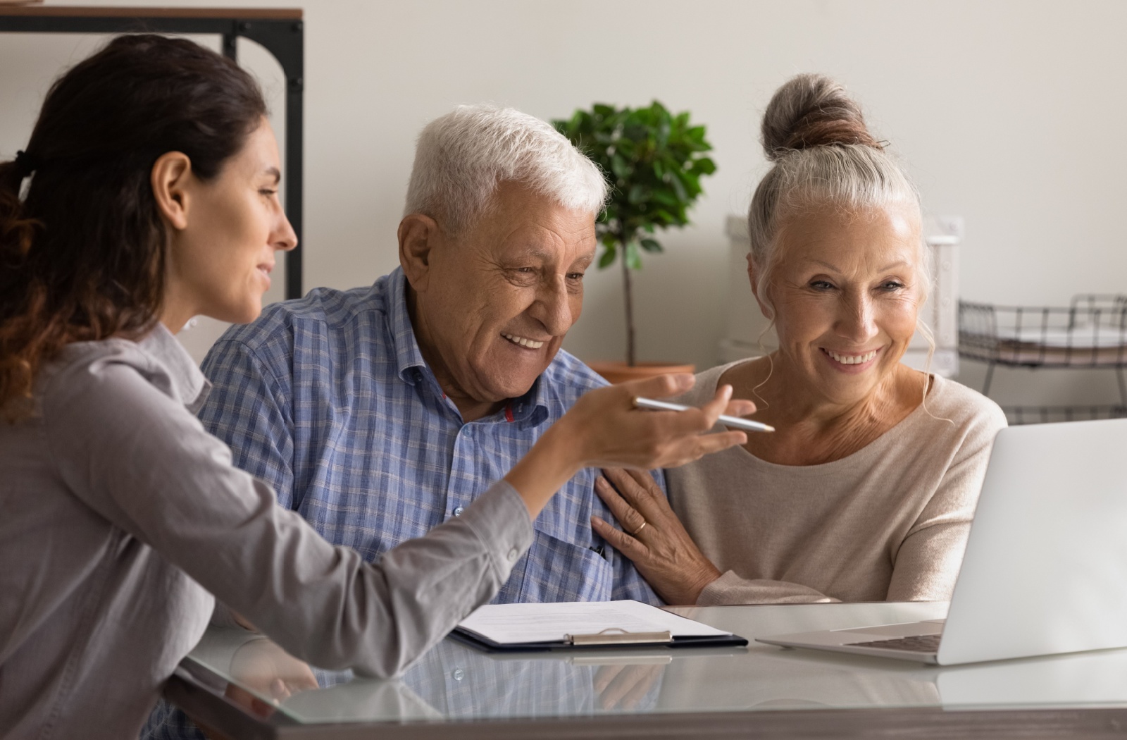 A financial advisor reviews a happy senior couple's finances with them and helps them develop a plan for long-term senior care.
