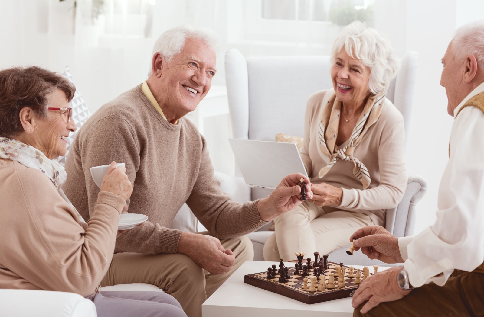 A group of senior enjoy tea and a game of chess at the adult day center.